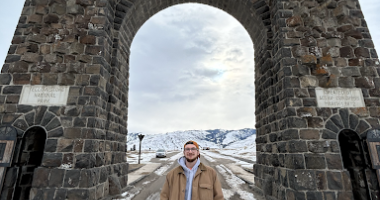 Nature Up North Project Manager Dan French stands under the Yellowstone National Park Roosevelt Arch.