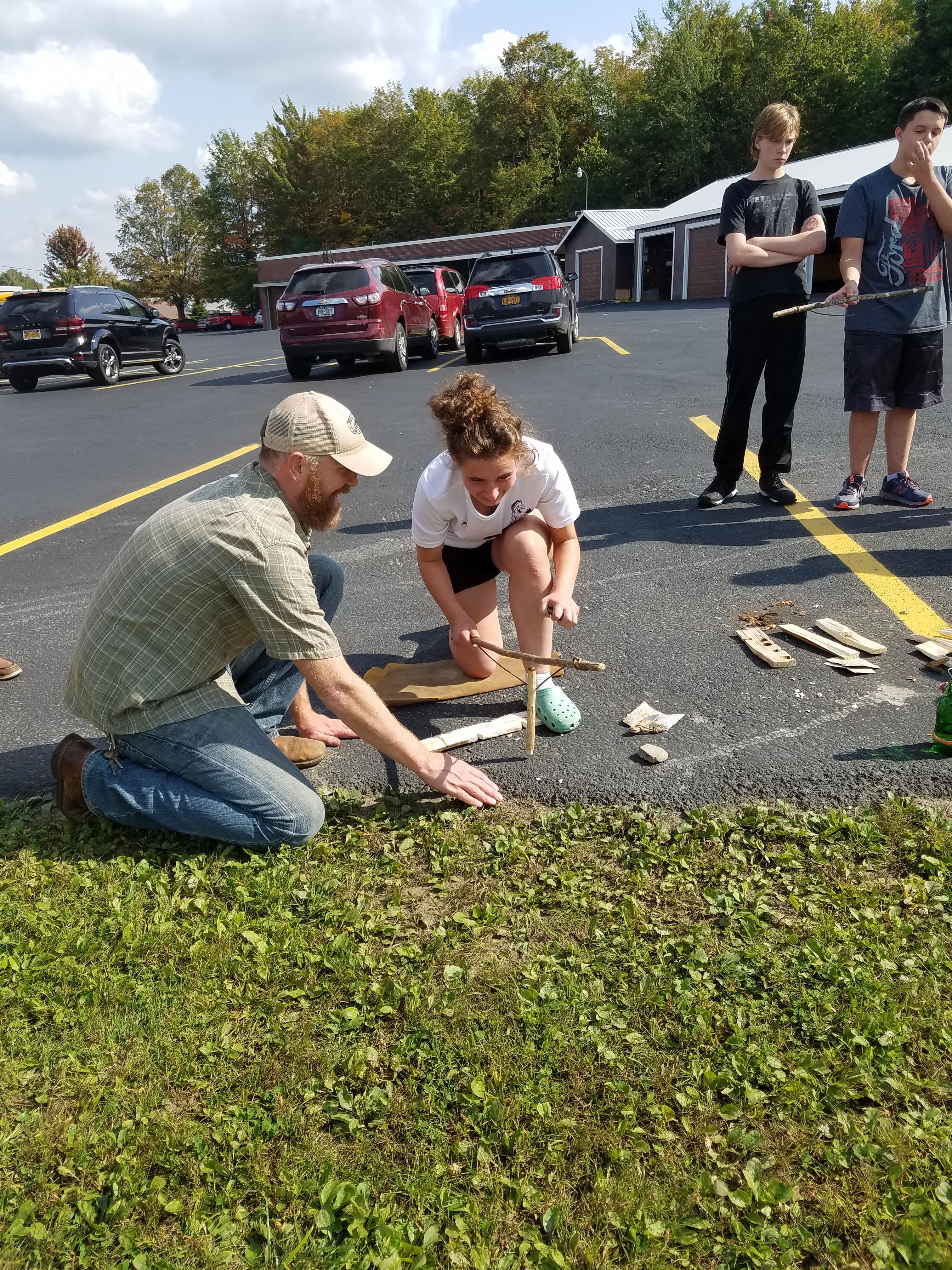 Dr. Messner teaches a student how to work with a bow drill.
