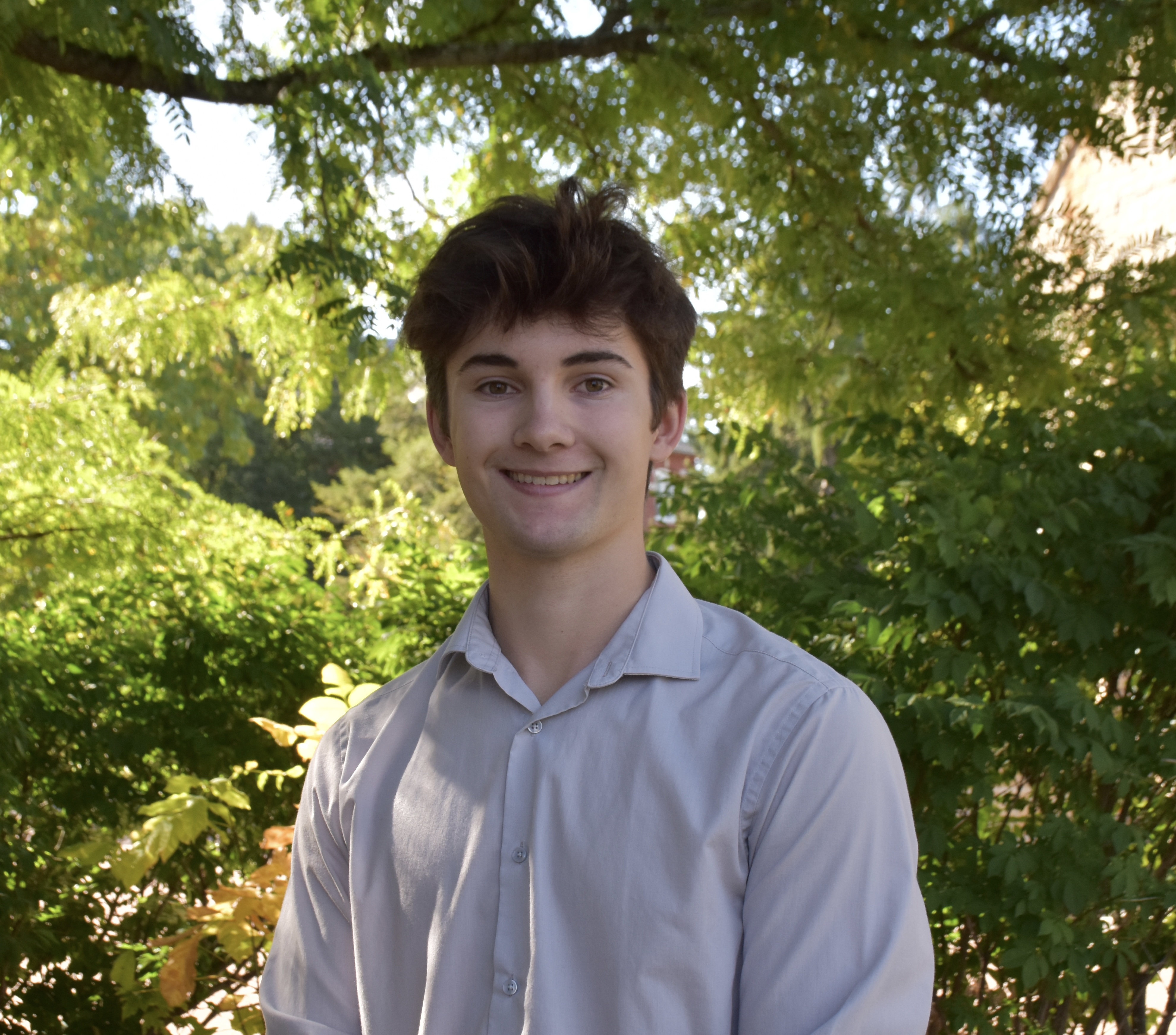 Photo of Cooper in front of greenery