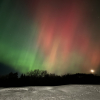 Red and green colored northern lights in the sky.