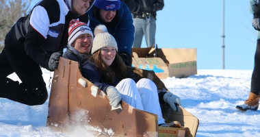 College team Calc-U-SUS from Clarkson goes for one last slide in their slightly tattered cardboard sled
