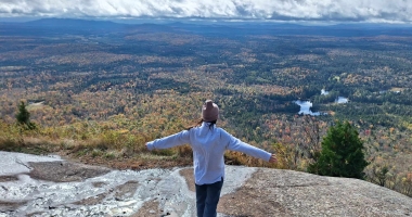 A Nature Up North Intern enjoys the view looking out from the peak of Azure Mountain.
