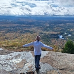 A Nature Up North Intern enjoys the view looking out from the peak of Azure Mountain.