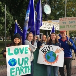 SLU students hold signs protesting climate change.