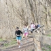 A group of people running down a wooded trail