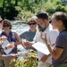 Teachers discussing water sampling lesson by river